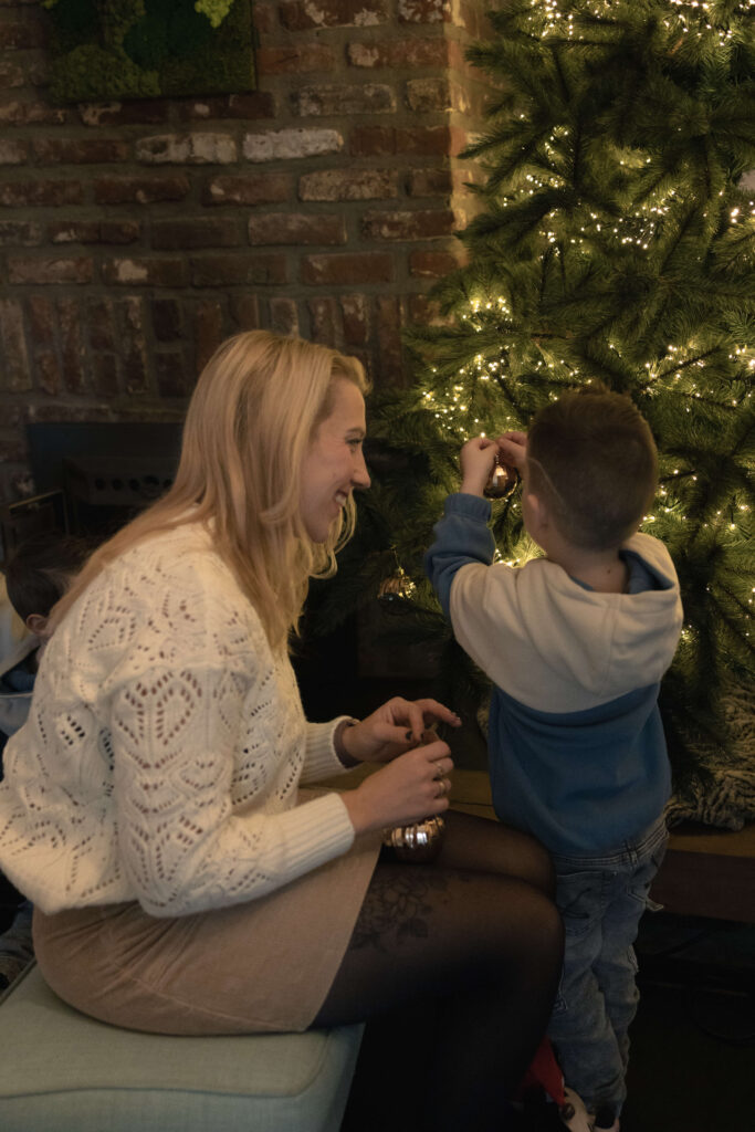 Liefdevolle blik moeder tijdens optuigen kerstboom
